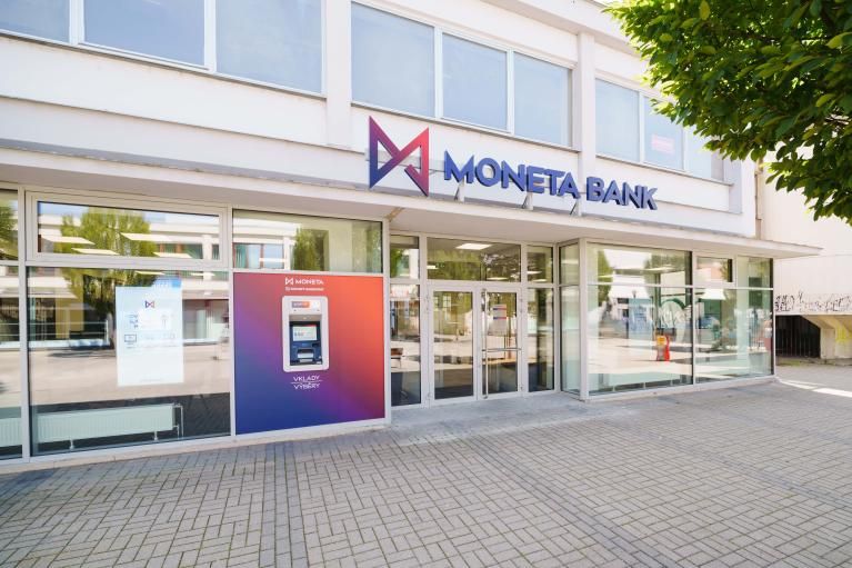 Pobočka MONETA Money Bank s logem a bankomatem v městské ulici